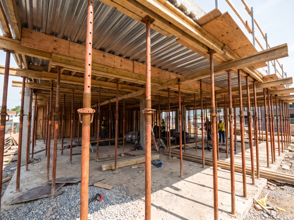 Grid of screw jack shoring posts supporting concrete formwork before a slab pour in Los Angeles